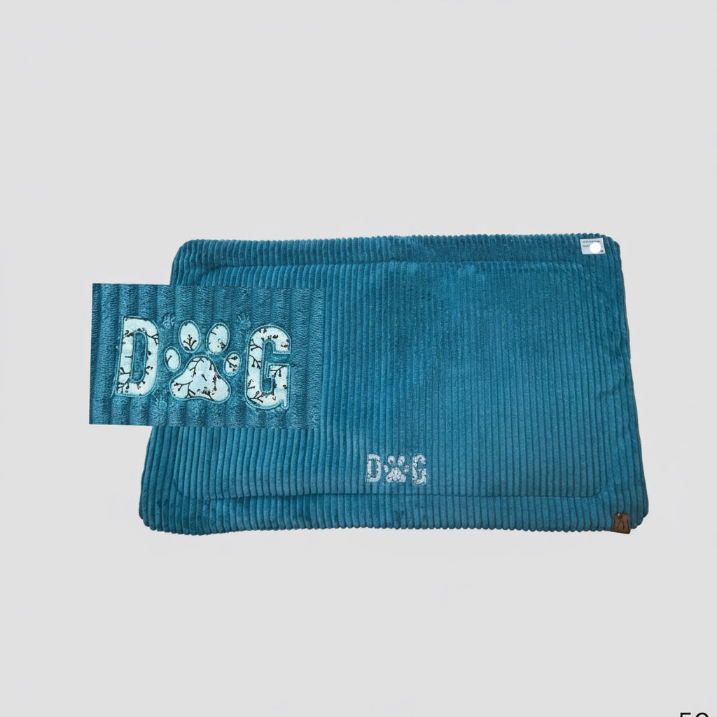 Hundedecke aus Breitcord mit Applikation „Dog“, bei der das „O“ eine Hundepfote ist. Die Farbei i türkis