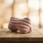 Leseknochen aus Kunstfell in altrosa auf einem rustikalen Holztisch